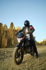 motorcyclist in black clothing posing in the valley of the animas in bolivia