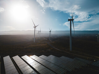 windmill and solar panel farm producing renewable energy with wind and sun