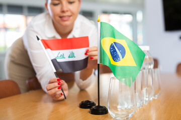Little flag of Brazil on table with bottles of water and flag of Iraq put next to it by positive...