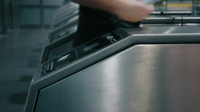 People passengers going through automatic turnstiles in subway station, entrance tourniquet to metro railway train platform. Ticket scanner. Close-up slow motion shot