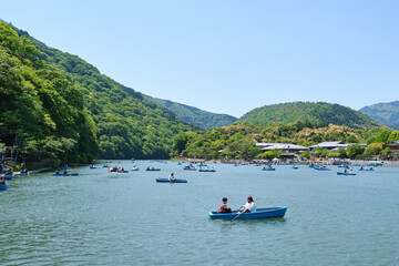 Fototapeta na wymiar Landscape of people in rowing boats on Katsura River in Arashiyama, Kyoto, Japan.