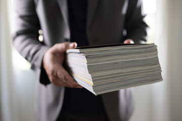 man holding a magazine publication page media stack to stack communication research data to learn...