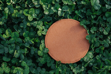 Clover background.Green blooming clover and brown round blank mockup.st patricks day background.Text place.Ecological concept