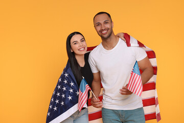 4th of July - Independence Day of USA. Happy couple with American flags on yellow background, space...