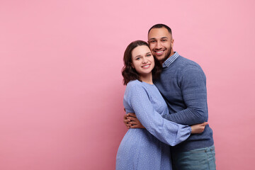 Lovely couple hugging on pink background, space for text. Valentine's day celebration