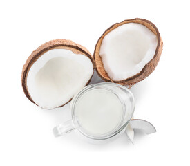 Glass jug of delicious vegan milk and coconuts on white background, top view