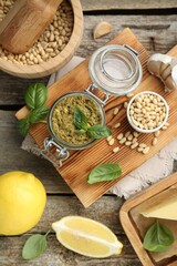 Delicious pesto sauce and ingredients on wooden table, flat lay