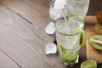 Glass of refreshing drink with kiwi on table, closeup. Space for text