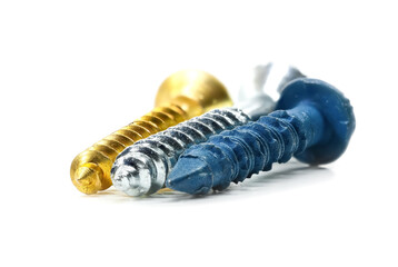 Close up view of three different color wood screws in gold, blue and silver colors on white background.