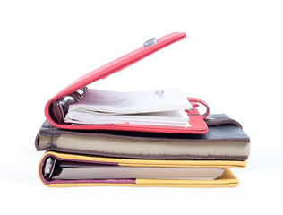 A stack of notebooks with a black and yellow cover and a red bookmark on the top