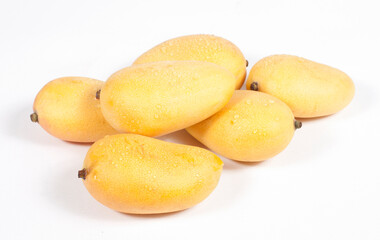 A pile of yellow mangoes on a white background