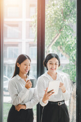 Two office workers talking with experienced colleague while using digital tablet in office, Colleagues discuss business.