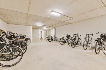 several bikes parked in a room with white walls and concrete flooring on the wall, there is an empty space for them to