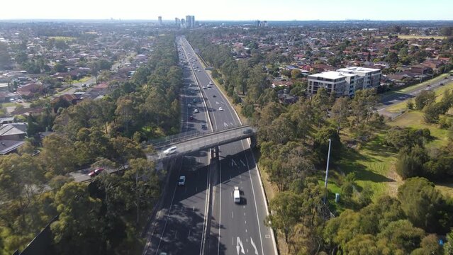 Aerial drone view above the South Western M5 Motorway at Casula in Sydney, NSW Australia with Liverpool CBD in the background 