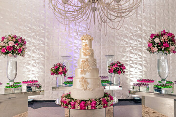 a wedding cake and trays of chocolate brigadeiro on top of a glass table