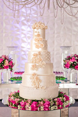 a wedding cake and trays of chocolate brigadeiro on top of a glass table