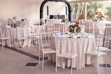 a ballroom with round tables with white tablecloths and decor on top