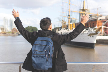 Back view of a tourist posing in front of a boat in Puerto Madero, Buenos Aires, Argentina