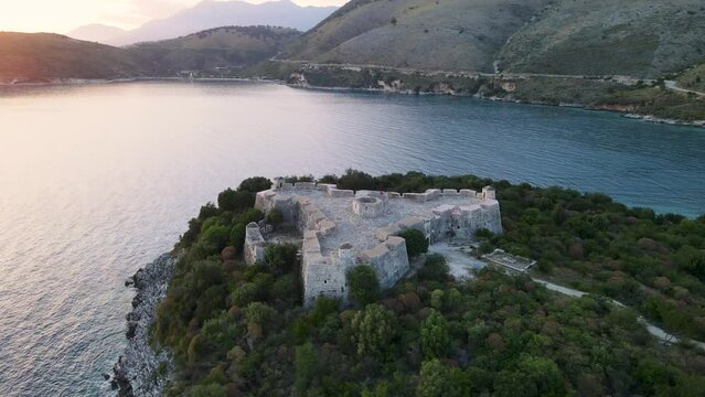 aerial view of Medieval architecture of fortress with sea view positioned on coastline of Mediterranean with amazing sunrise or sunset in background.
