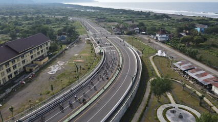 Aerial view of a wide road near the southern coast of Yogyakarta, passed by road bikers