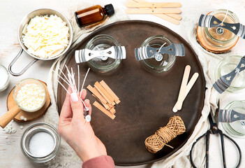 Set for homemade natural eco soy wax candles, Woman making decorative aroma candle at table.