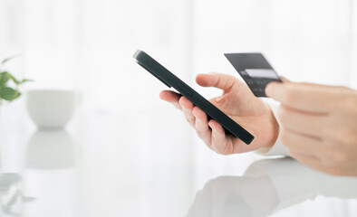 Online payment,woman's hands holding a credit card and using smart phone for online shopping