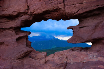 Garden of the Gods national park Keyhole Window with Pikes Peak in the spring with lush green forest trees in Colorado Springs, CO USA.