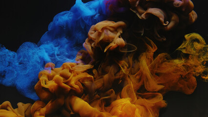 Ink water shot. Color smoke splash. Underwater dye explosion. Blue yellow fluid paint mix on dark...