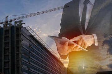 Couple exposure of businessman using tablet with cityscape and financial graph on blurred building background. Modern city.