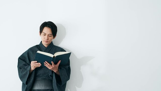 和服で本を読む男性