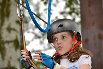 Fototapeta na wymiar adventure climbing high wire park - people on course in mountain helmet and safety equipment. High quality photo