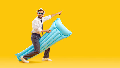 Funny bearded man wearing office clothes with shirt and tie holding inflatable mattress and having fun isolated on yellow background. Happy tourist is going on summer holiday trip. Vacation concept.