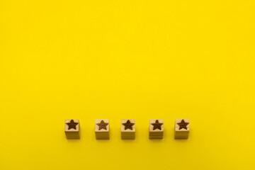 星マークのウッドキューブが立体的に5つ下部に並んでいる黄色い背景