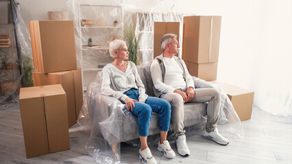 Rent apartment. House relocating. Upset family man woman sitting sofa in new home dissatisfied flat...