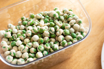 A view of a container full of wasabi peas snack.