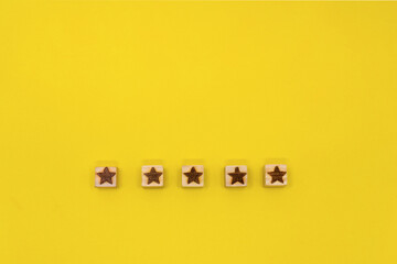 星マークのウッドキューブが5つ下部に並んでいる黄色い背景
