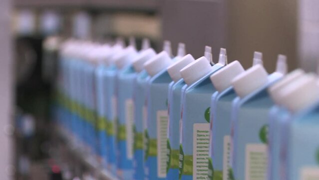 A line of dairy products. Packages of dairy products are moved along a conveyor line at the factory. Production conveyor belt at the dairy plant.