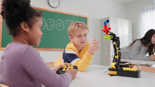 Smart primary students grouping to learning robot free electives with female teacher in classroom. Caucasian teacher female teach childrens assemble robot in science subject at elementary school.