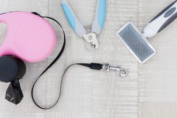Pink retractable dog leash, nail clipper and hair comb