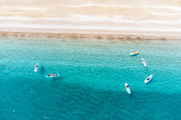 Aerial view of a beach in Turkey with group of sup boarders swimming in the sea. Paradise resort...