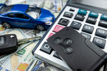 auto loan concept - small toy vechile, keys calculator and money all for buy or rent