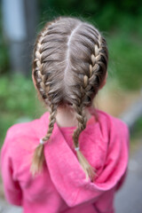 Blonde child with plaited stylish hair