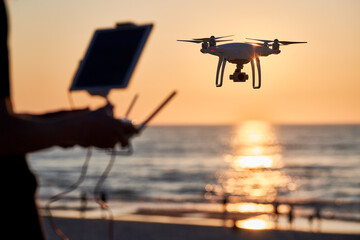 Drone operated by young man flying over an sea - 616907147