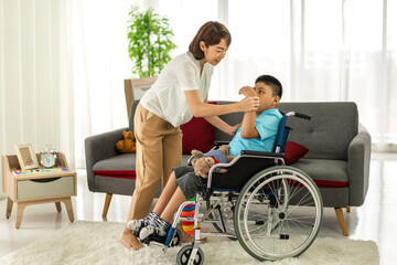 Portrait of asian physiotherapist carer helping and playing with disabled child health problem by doing exercises in rehabilitation clinic.disability care concept