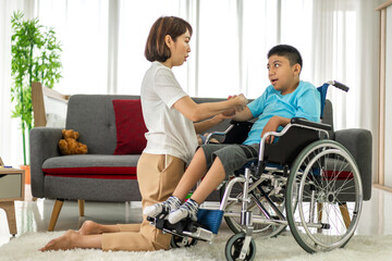Portrait of asian physiotherapist carer helping and playing with disabled child health problem by doing exercises in rehabilitation clinic.disability care concept