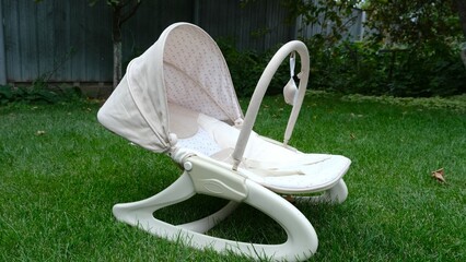 Photo of a baby cradle standing on the lawn.