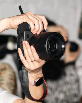 Female hands with beautiful manicure holding a photo camera on a blurred background