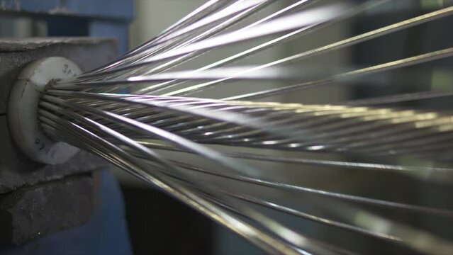 A close up of High tensile strength cable manufacturing. wire twisting process in automated machine
