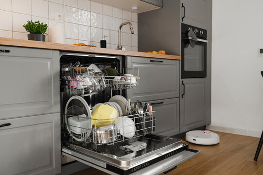 Washed dishes inside dishwasher in kitchen at home