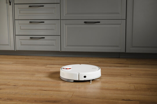 Robot vacuum cleaner near drawers at home